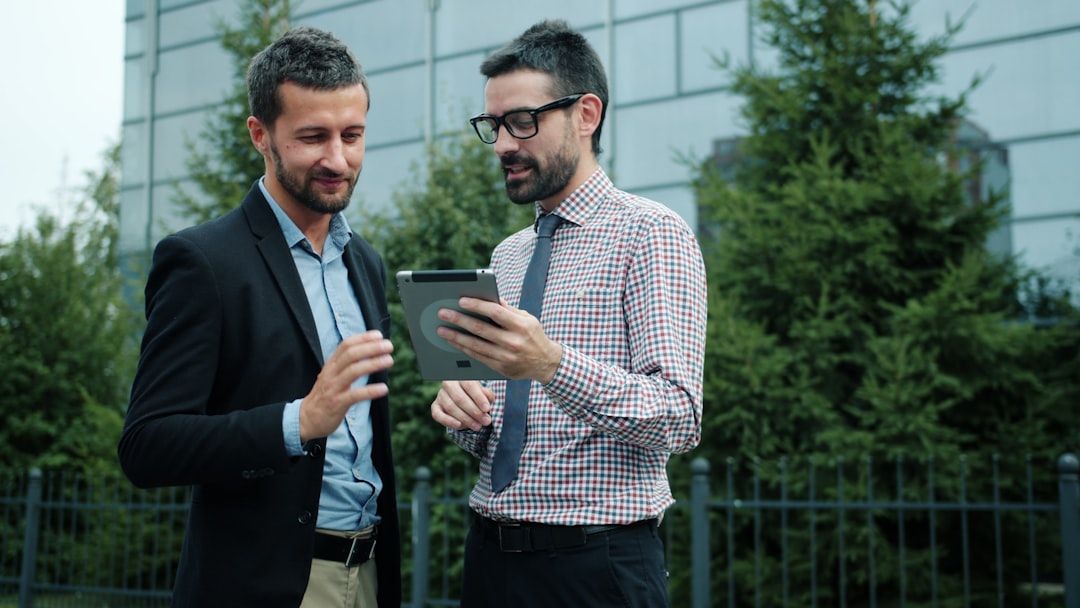 Businessmen using tablet outdoors